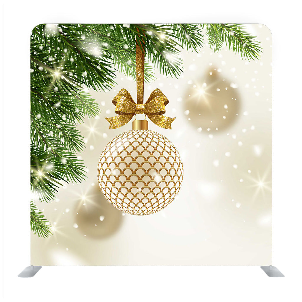 Adorno dorado estampado con lazo dorado brillante colgado en una pared multimedia de árbol de Navidad